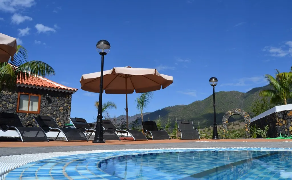 Sombrillas y tumbonas junto a la piscina